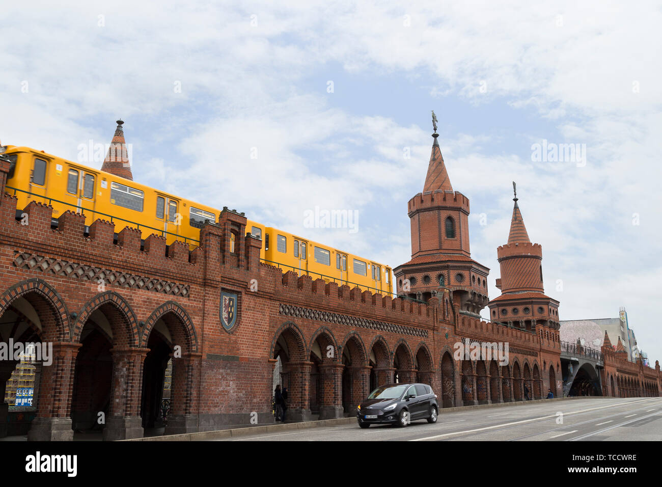 Jaune vieux train de métro (U-Bahn) traversant le célèbre Pont Oberbaum (Oberbaumbrucke) à Berlin, Allemagne, à jour. Banque D'Images