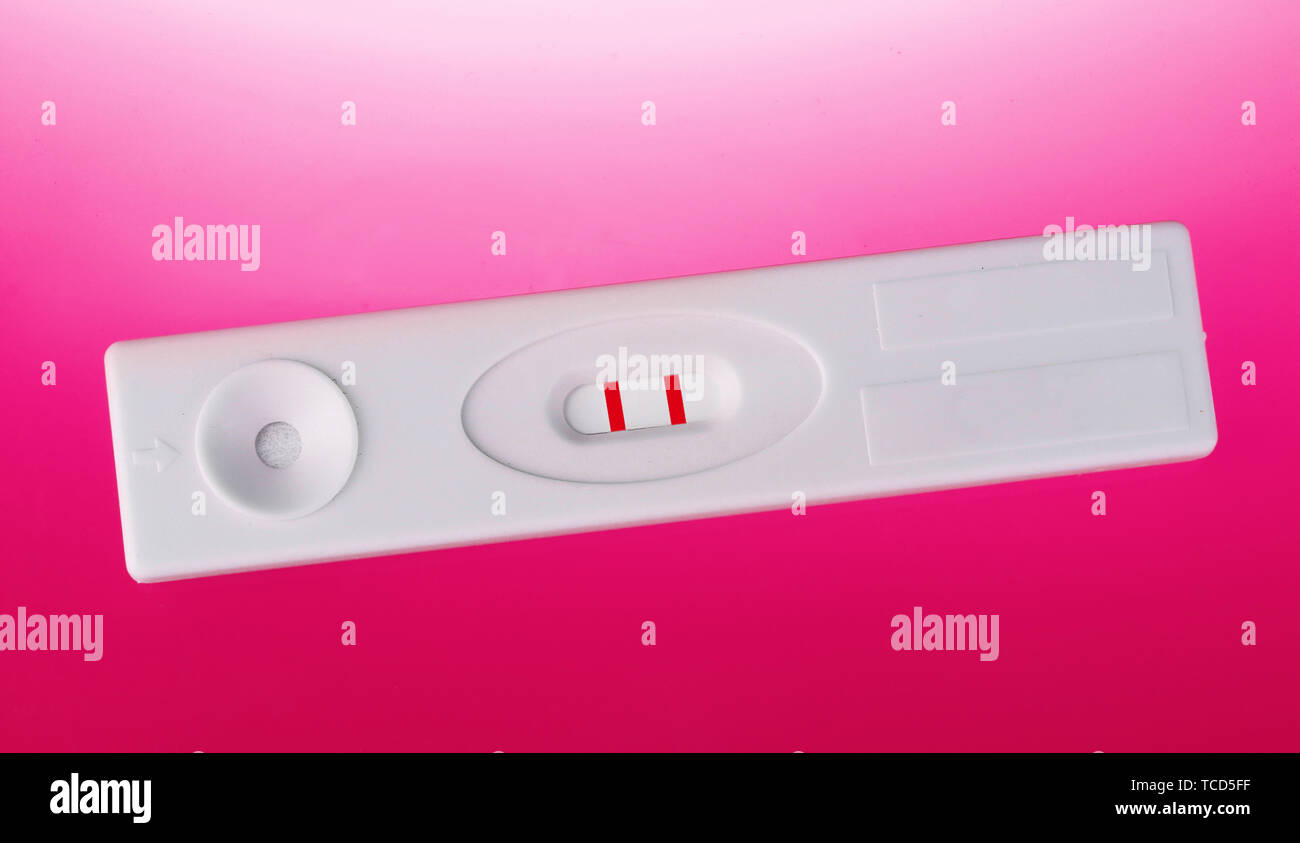 Test de grossesse positif sur fond rose Banque D'Images