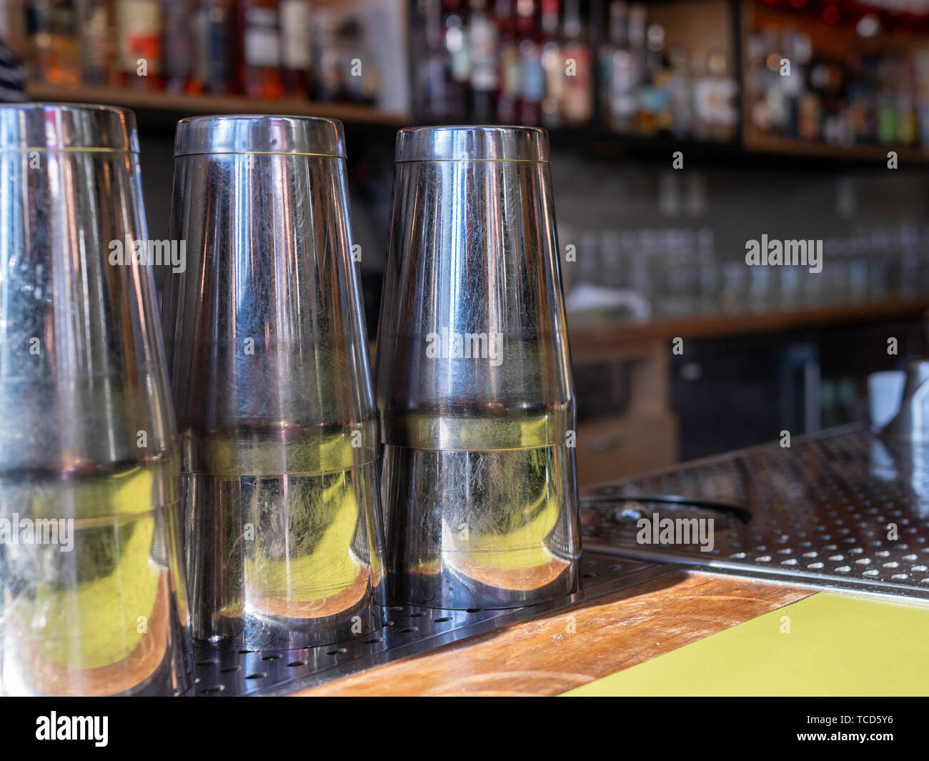 Plusieurs agitateurs verre acier assis sur un comptoir bar prêt à faire des cocktails Banque D'Images