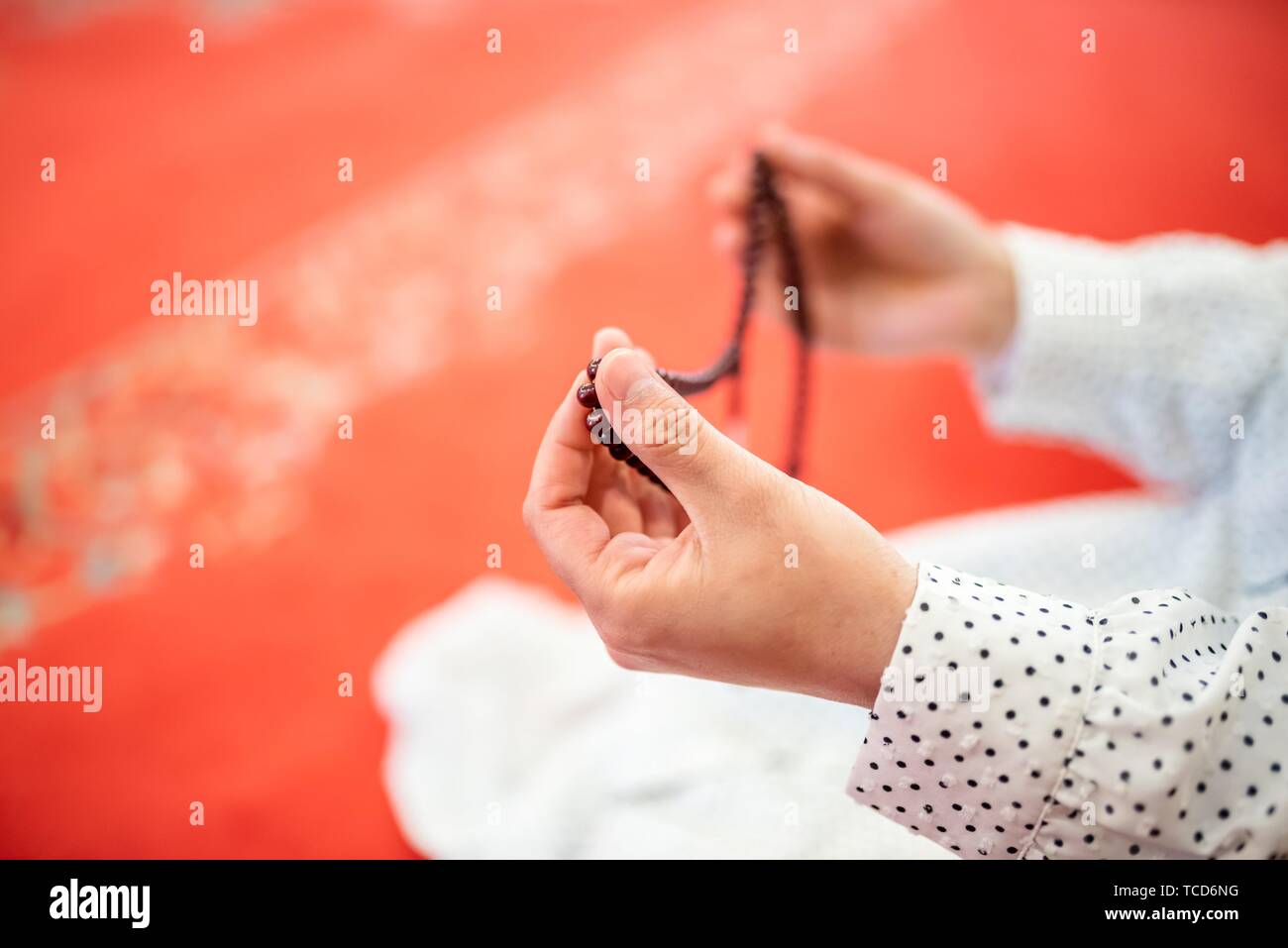 Vue rapprochée d'une femme musulmane dans les mains tout en maintenant l'hijab chapelet avec ses mains et en priant. Prier Religion concept. Banque D'Images