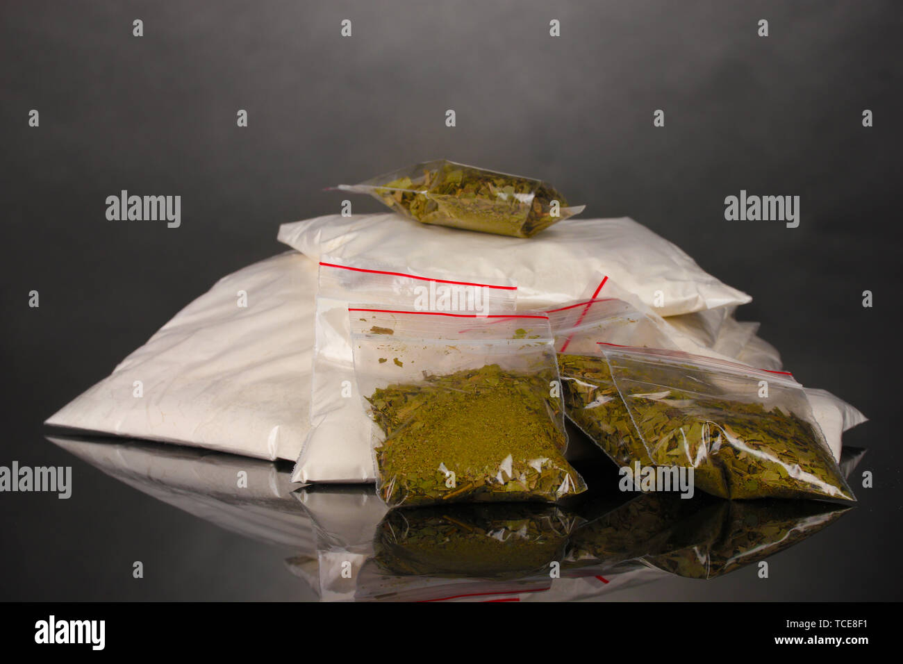 La cocaïne et la marihuana en paquets sur fond gris Banque D'Images