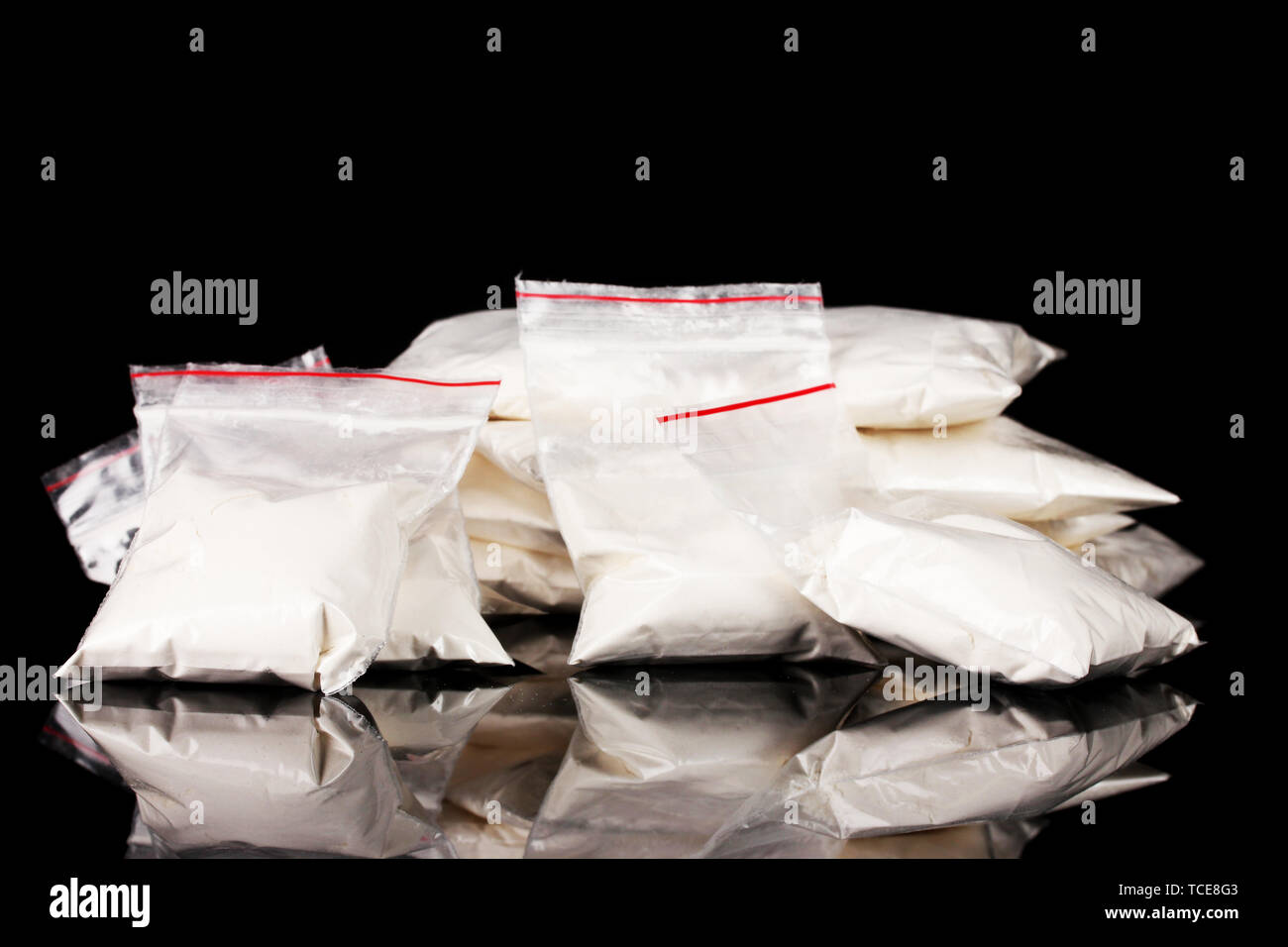La cocaïne en paquets sur fond noir Banque D'Images