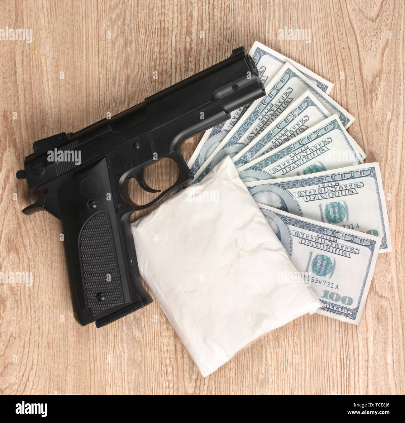 La cocaïne en paquet, dollars avec pistolet sur fond de bois Banque D'Images
