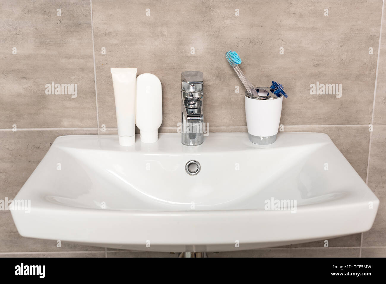 Le rasage rasoir, brosse à dents, du dentifrice et du shampoing du lavabo dans la salle de bains Banque D'Images