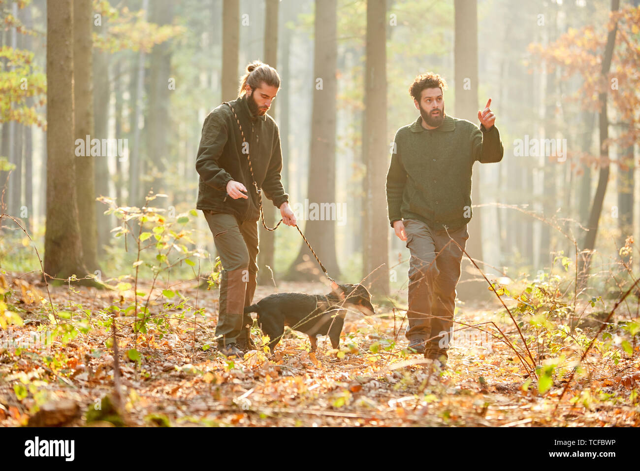 Deux chasseurs avec chien de chasse sur une chasse ou une randonnée dans la forêt Banque D'Images