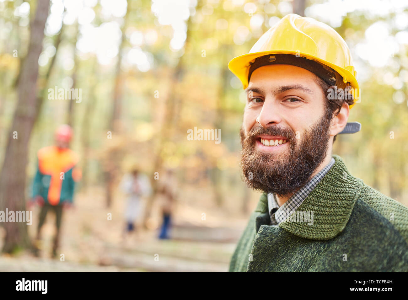 Travailleur forestier ou travailleur forestier sourit de contentement tout en travaillant dans la forêt Banque D'Images