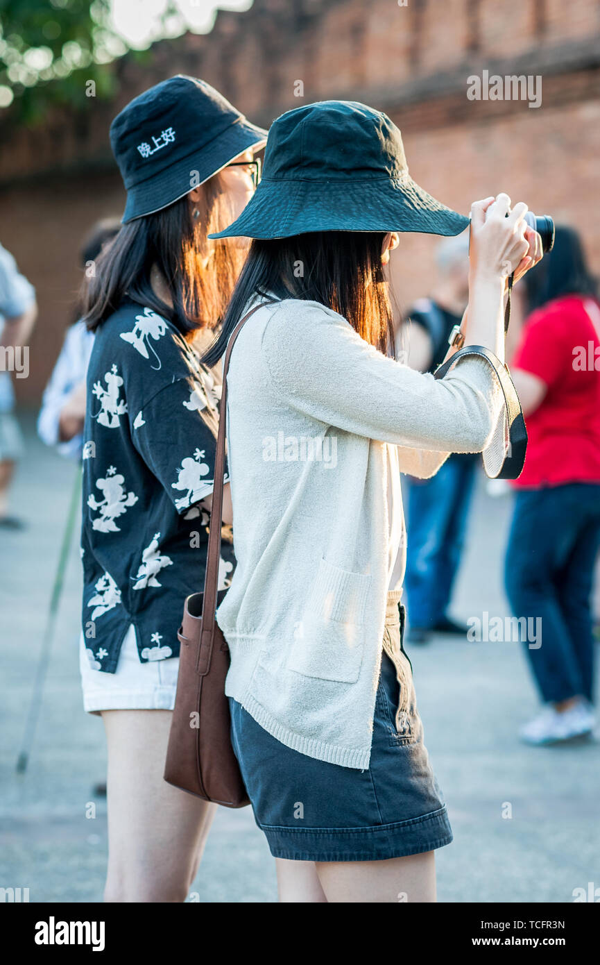 Des groupes de touristes asiatiques femmes apprécient les sites touristiques de Chiang Mai Thaïlande. Ici, ils photographient à Tha Pae Gate, un lieu touristique populaire. Banque D'Images