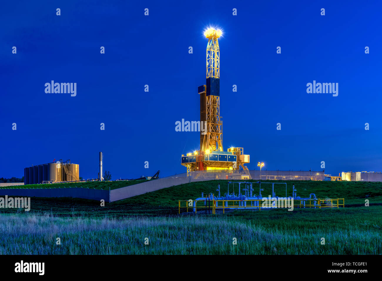 Une plate-forme de forage dans la nuit dans les champs de pétrole de Bakken jouer près de Williston, Dakota du Nord, USA. Banque D'Images