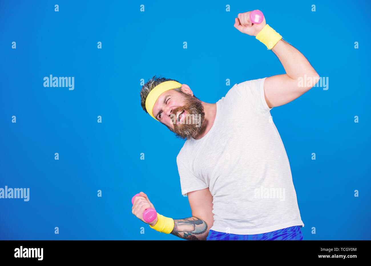 Athlète Motivé guy. Formation de sportif avec haltères fond bleu. Améliorer vos muscles. Utiliser des poids ou haltères. L'homme sportif barbu exercice haltère. L'entraînement avec haltères minuscules. Banque D'Images