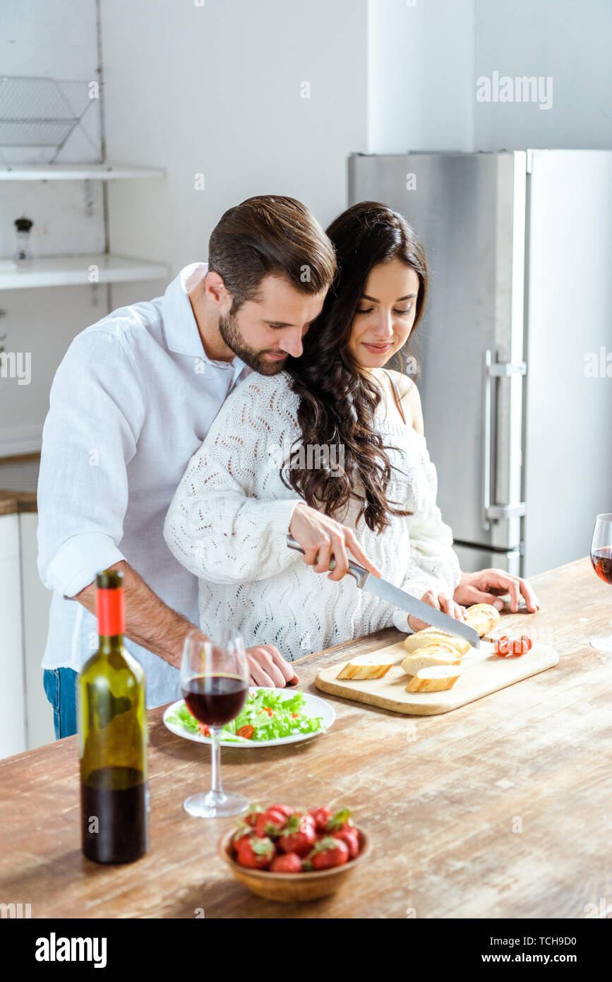 Couple heureux ensemble à dîner de cuisine équipée Banque D'Images