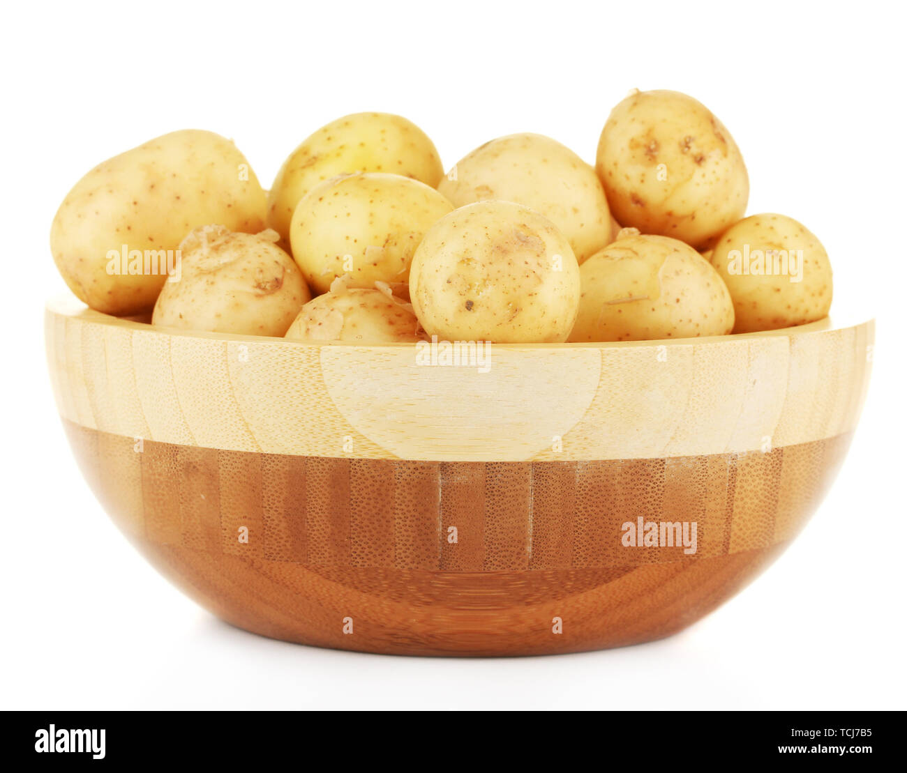 Les jeunes pommes de terre dans un bol en bois isolé sur blanc Banque D'Images