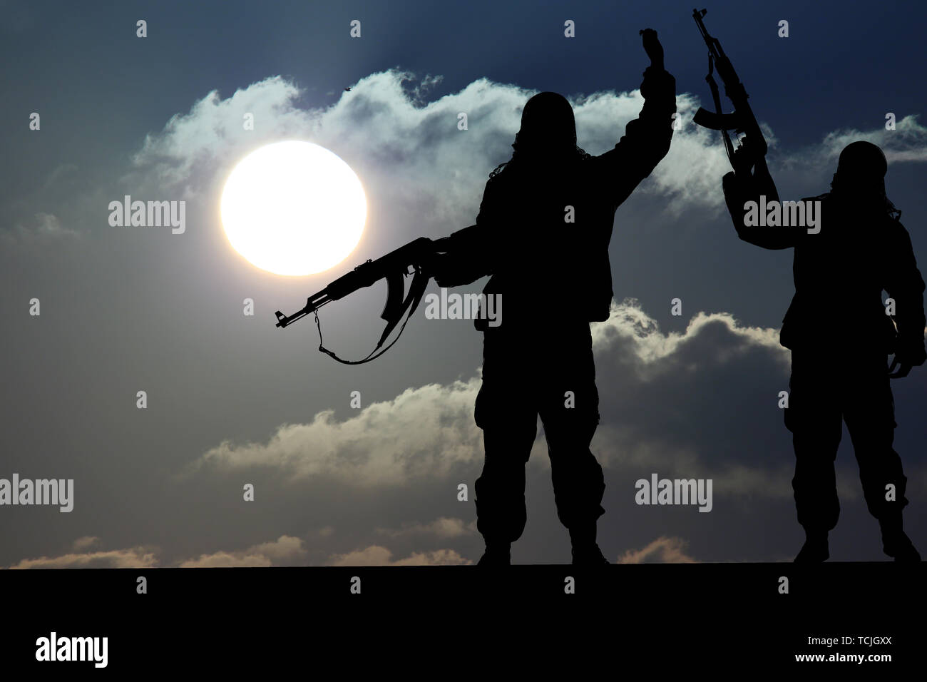 Silhouette de soldat ou l'officier militaire avec des armes au coucher du soleil. shot, holding gun, ciel coloré, concept d'un terroriste. Avec les terroristes Silhouette Banque D'Images