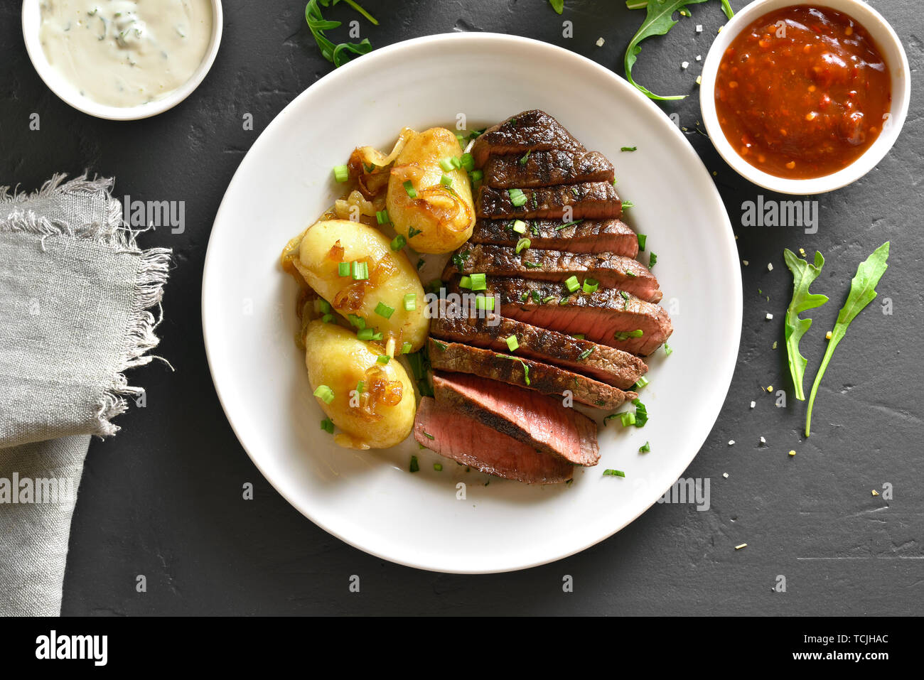 Rosé rôti de bœuf avec des pommes de terre au fond de la pierre noire. Haut de la vue, télévision lay Banque D'Images