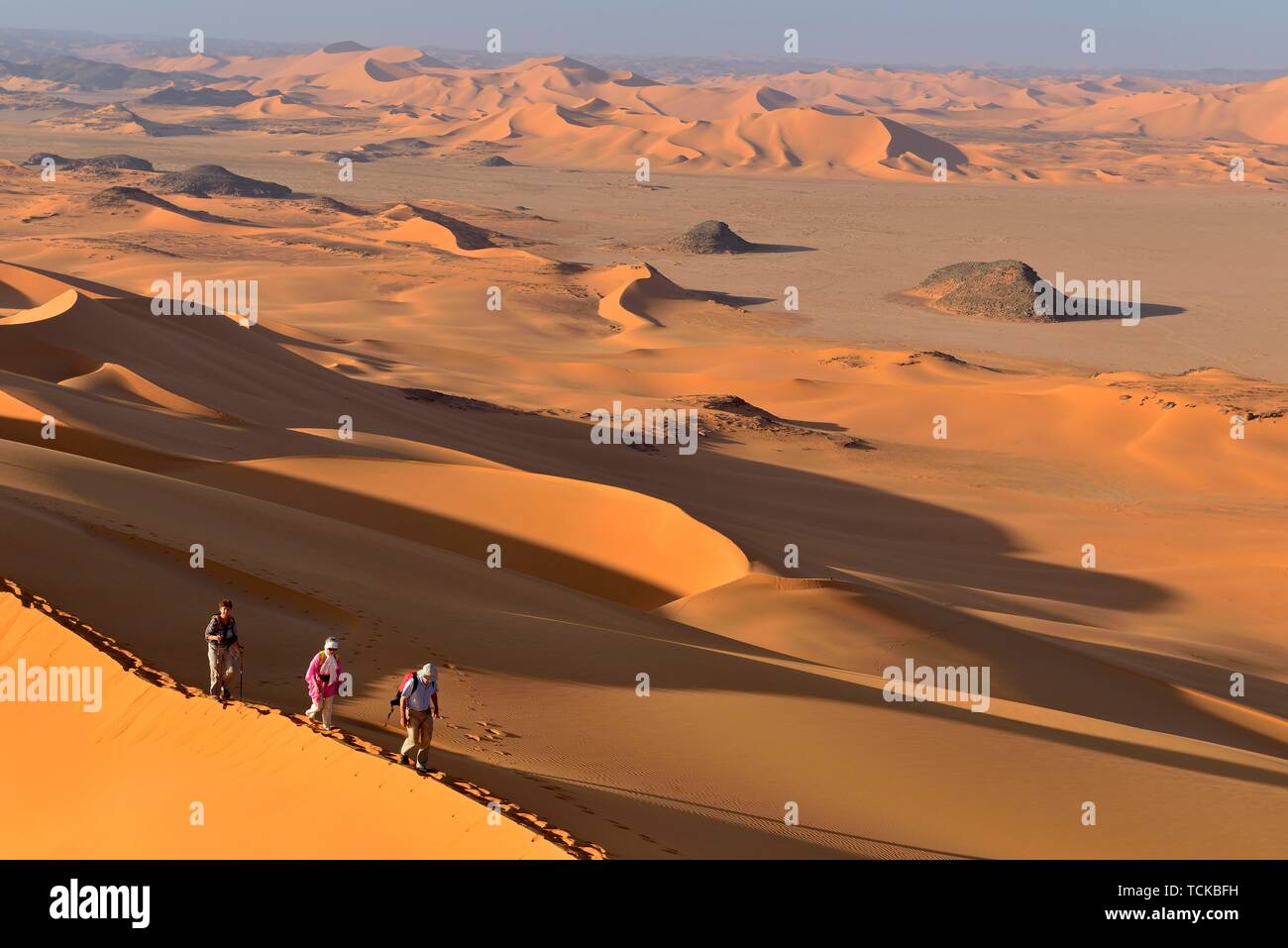 Groupe de personnes de la randonnée dans la sanddunes de Egedi Dans Djerane, Tassili N'Ajjer National Park, l'Algérie, Sahara, Afrique Banque D'Images Groupe de personnes de la randonnée dans la sanddunes de Egedi Dans Djerane, Tassili N'Ajjer National Park, l'Algérie, Sahara, Afrique Banque D'Images
