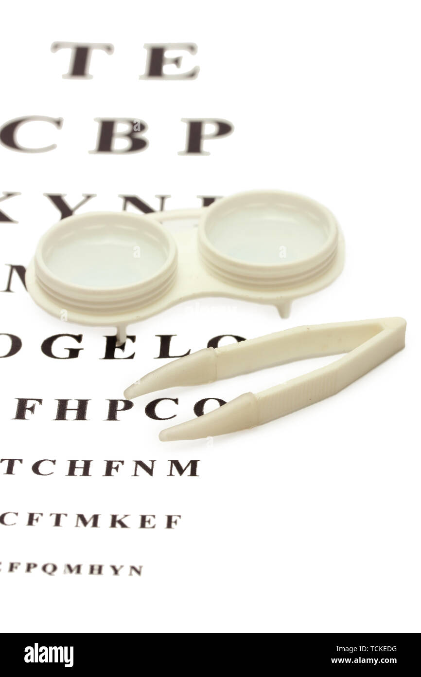 Les verres de contact dans des conteneurs et des pincettes, , sur l'échelle Snellen eye fond du graphique Banque D'Images