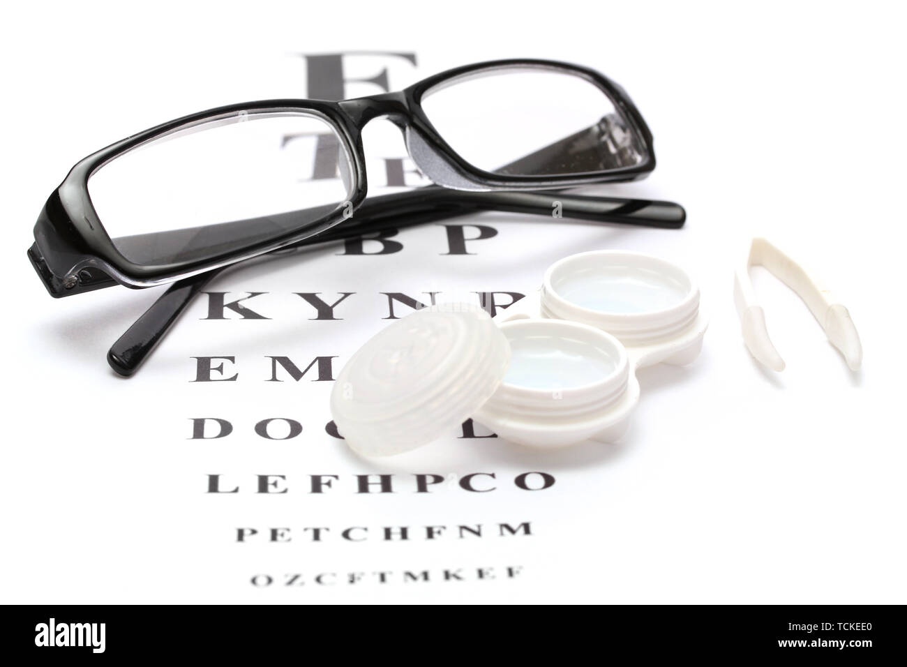 Lunettes, Lentilles de contact dans des conteneurs et des pincettes, sur l'échelle Snellen eye fond du graphique Banque D'Images