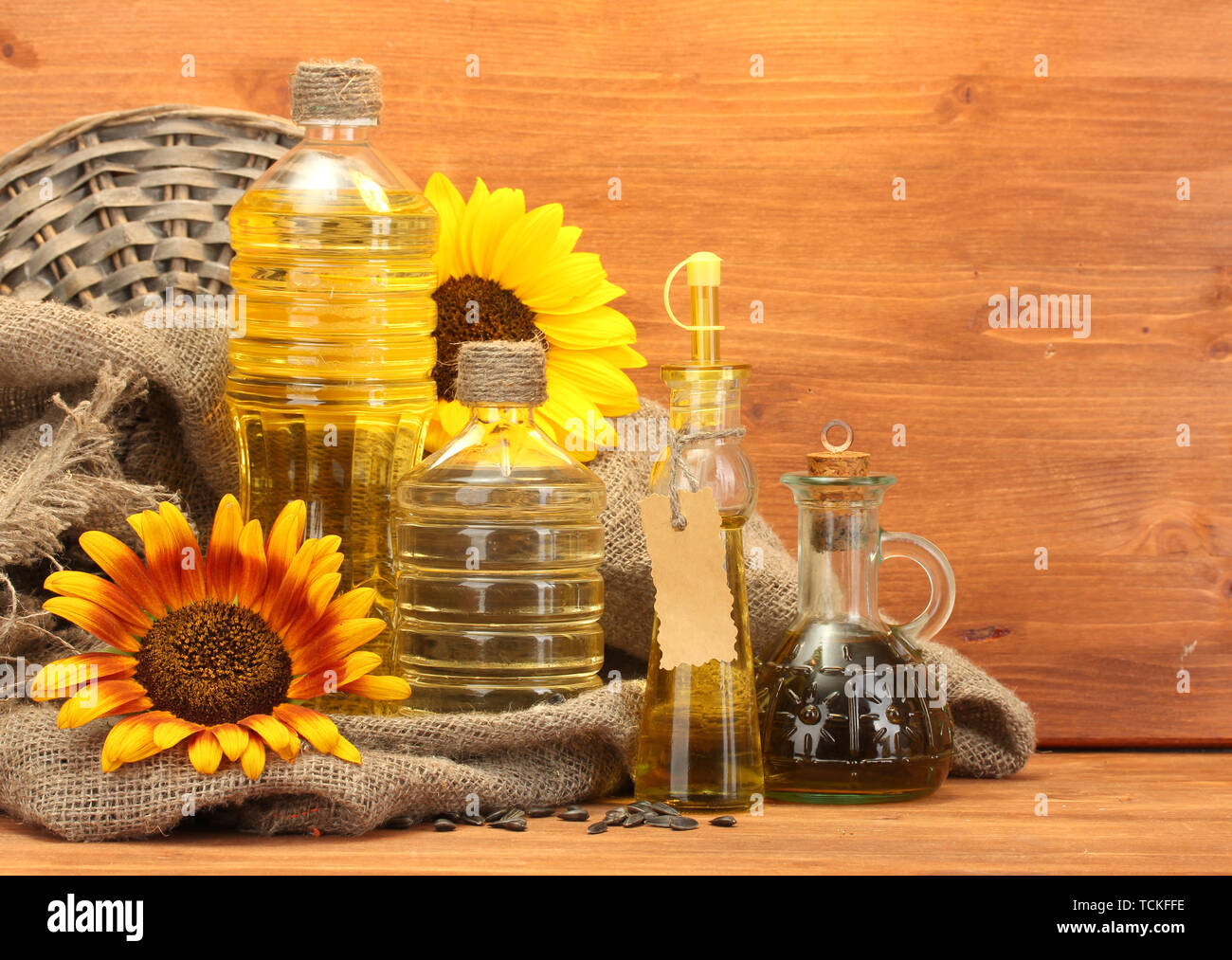 En bouteilles d'huile, de tournesol et de graines, sur fond de bois Banque D'Images