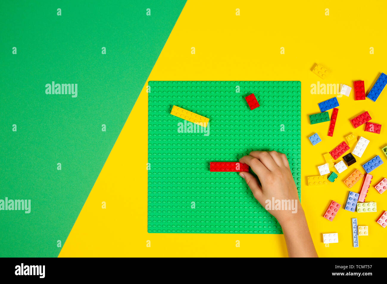 Vilnius, Lituanie - Février 23, 2019. Les mains des enfants jouer avec des blocs lego colorés sur la table Banque D'Images