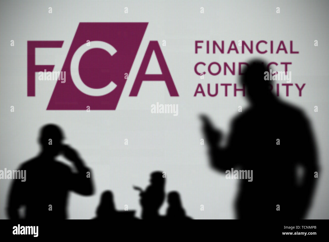 Le logo de l'ACF est vu sur un écran LED à l'arrière-plan tandis qu'une personne utilise la silhouette d'un smartphone dans l'avant-plan (usage éditorial uniquement) Banque D'Images