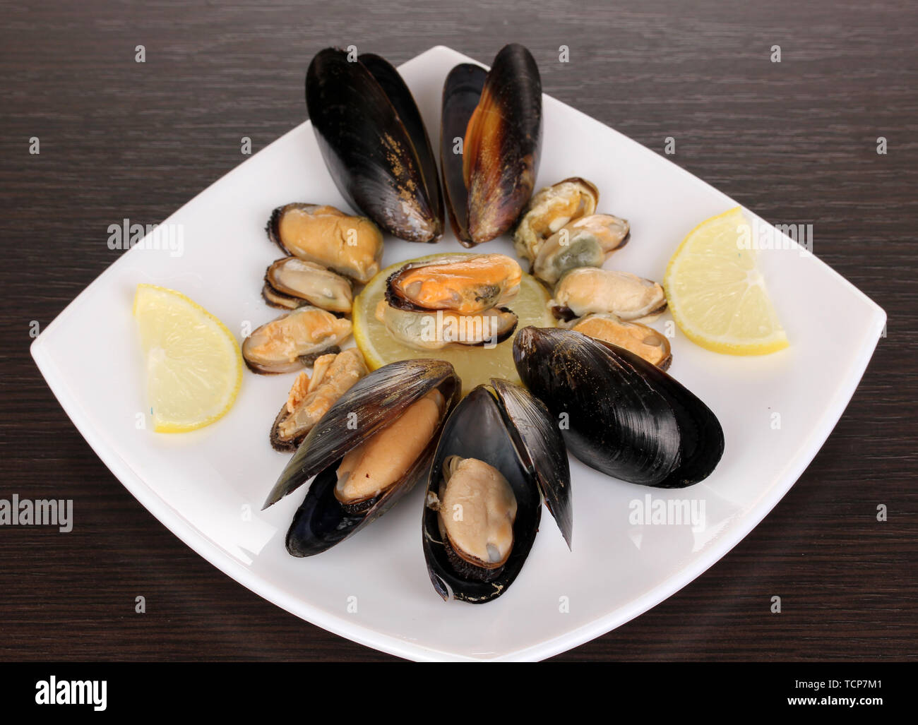 Snack de moules et de citron sur l'assiette sur la table en bois Banque D'Images