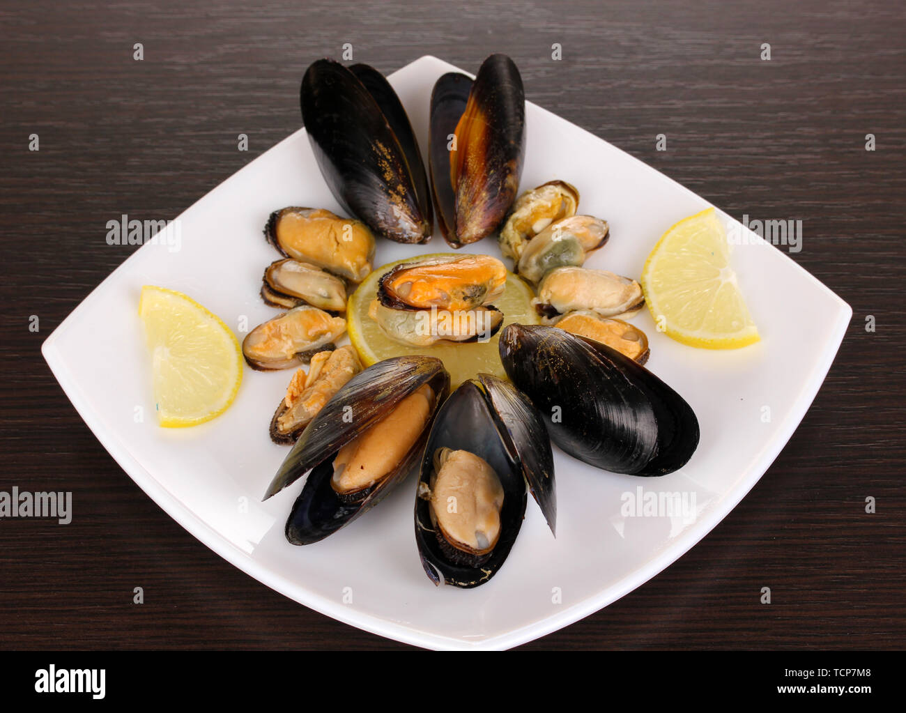 Snack de moules et de citron sur l'assiette sur la table en bois Banque D'Images