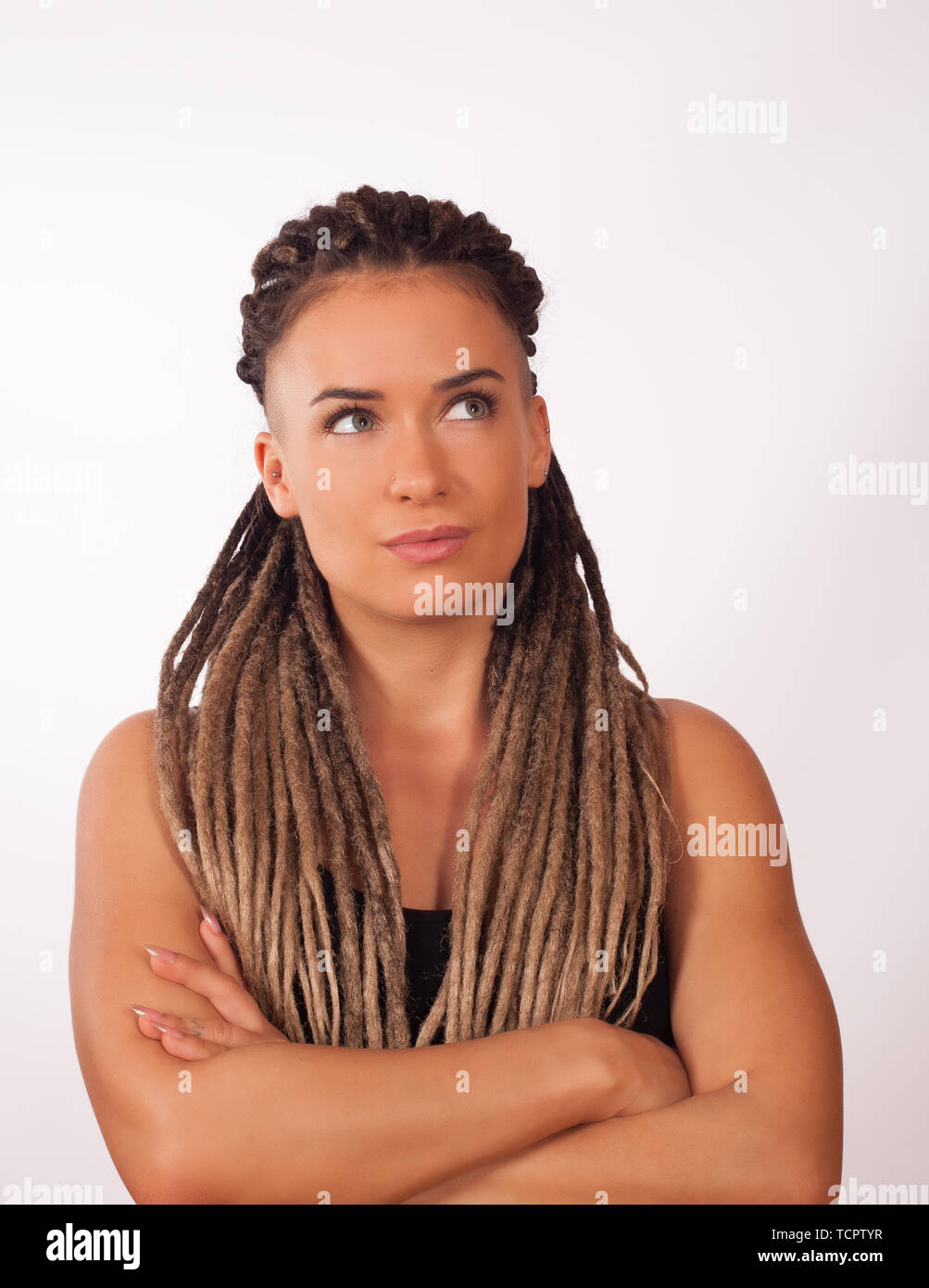 Portrait d'une fille européenne avec des tresses africaines et rasé des temples sur un fond blanc Banque D'Images