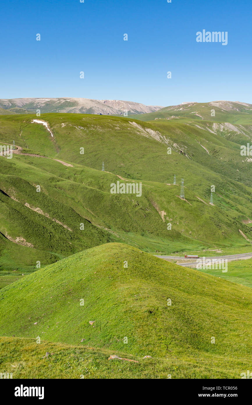 Les prairies alpines le long de la G217 Duku sous l'autoroute l'été, ciel bleu et nuages blancs dans le Xinjiang, Chine Banque D'Images