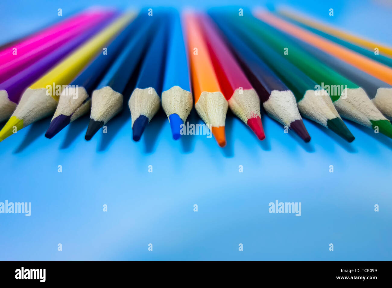 Un crayon de couleur sont soigneusement disposées dans un fond bleu Banque D'Images