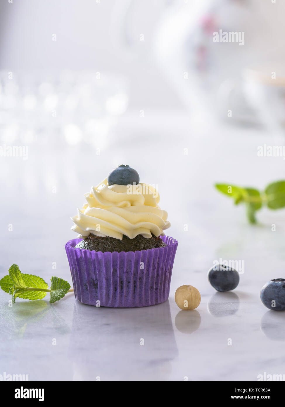 Avec Cupcake Blueberry et de noisette en violet sur papier naturel blanc en surface. Banque D'Images