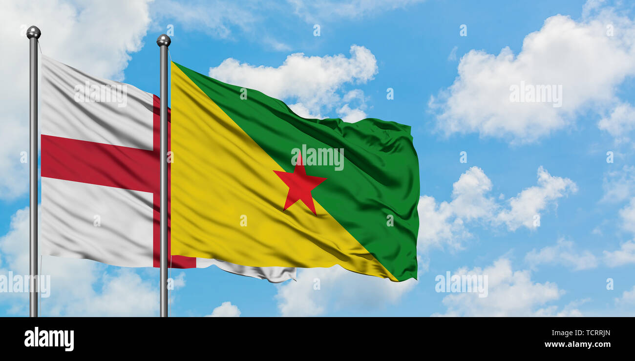 L'Angleterre et de brandir le drapeau de la Guyane française dans le vent contre ciel bleu nuageux blanc ensemble. Concept de diplomatie, de relations internationales. Banque D'Images