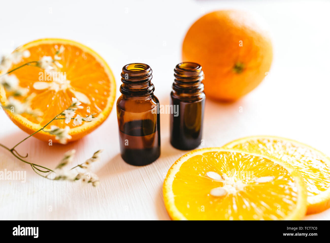 Deux bouteilles d'huile essentielle d'orange sur fond blanc pour la beauté, soins de la peau, bien-être et à des fins médicinales. Banque D'Images