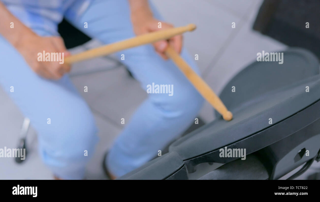 Femme jouant sur un ensemble de batterie électronique Banque D'Images