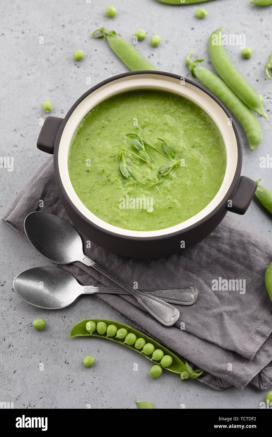 Soupe aux pois frais dans un bol avec des cuillères et des nappes Banque D'Images