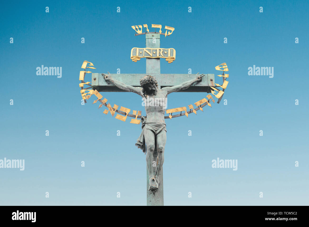 La statue de Jésus Christ sur le pont Charles à Prague, République tchèque contre le ciel bleu. Banque D'Images