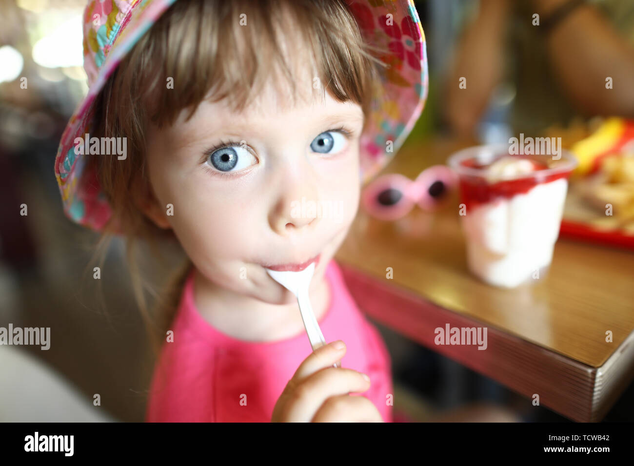 Satisfait petit enfant lèche avec de la glace à la cuillère Banque D'Images