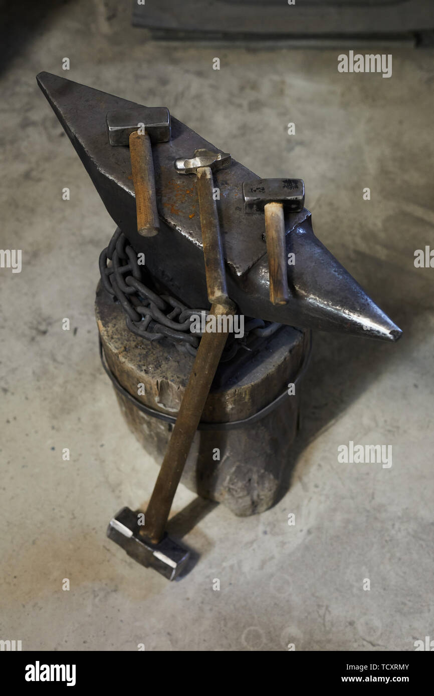 Voir ci-dessus des différents marteaux pour forger de place sur enclume en acier, gros marteau sur enclume penchée dans l'atelier Banque D'Images