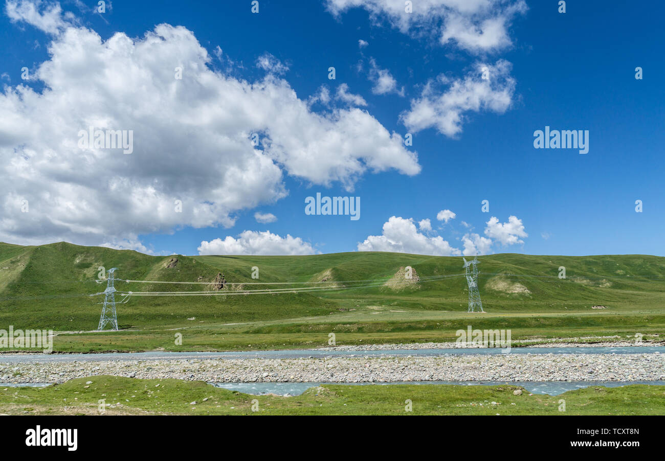 Les prairies alpines le long de la G217 Duku sous l'autoroute l'été, ciel bleu et nuages blancs dans le Xinjiang, Chine Banque D'Images