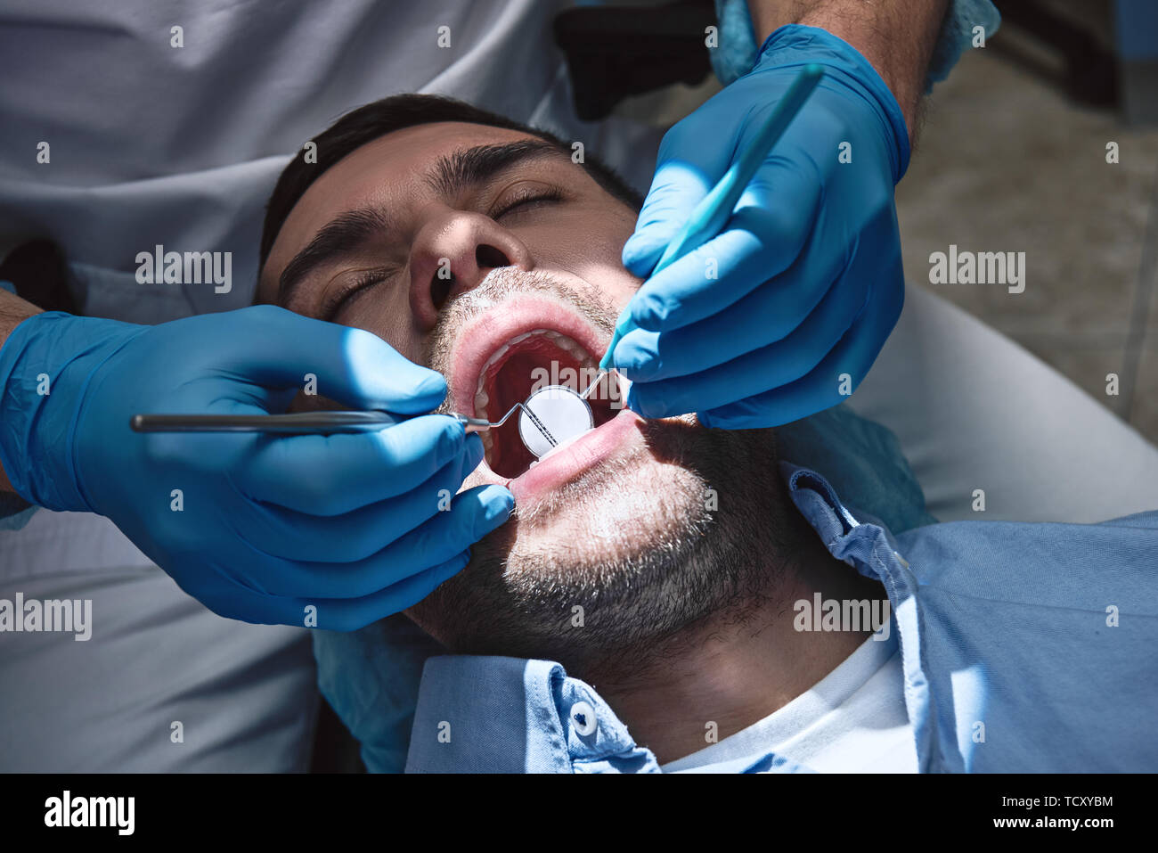 Portrait de dentiste de dents du patient à l'aide de miroir de la bouche et de dental explorer. Outils de dentiste. Le traitement. Clinique dentaire moderne. L'horizontale Banque D'Images