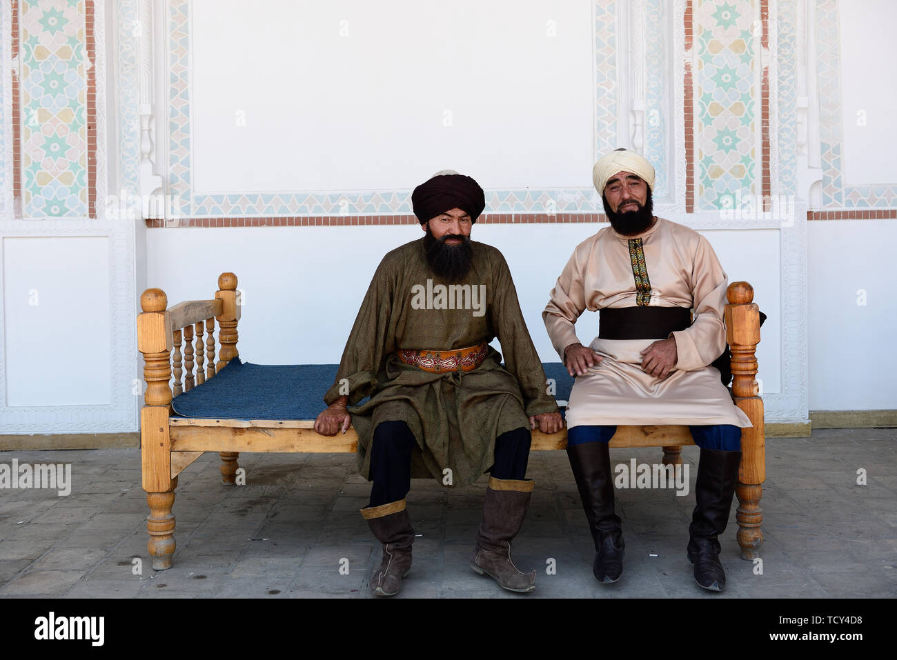 Kokand, vallée de Ferghana, en Ouzbékistan - 4 juin 2019 : les hommes, habillés en ouzbek dans le turban traditionnel, assis sur le banc dans le palais de Khuda Banque D'Images