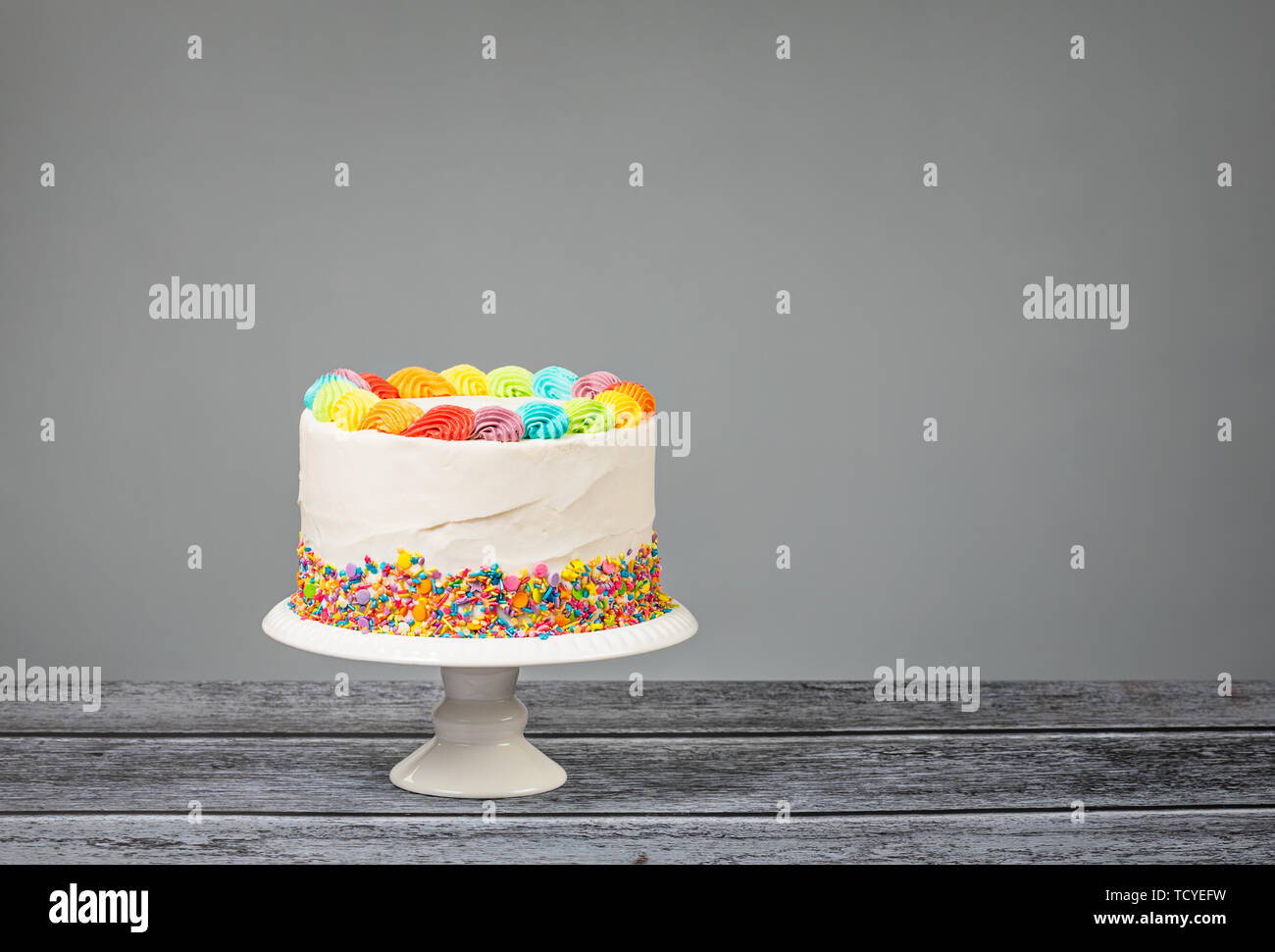 Anniversaire Gateau Avec Glacage Colore Et Arc En Ciel Sur Un Fond Gris De Sprinkles Photo Stock Alamy