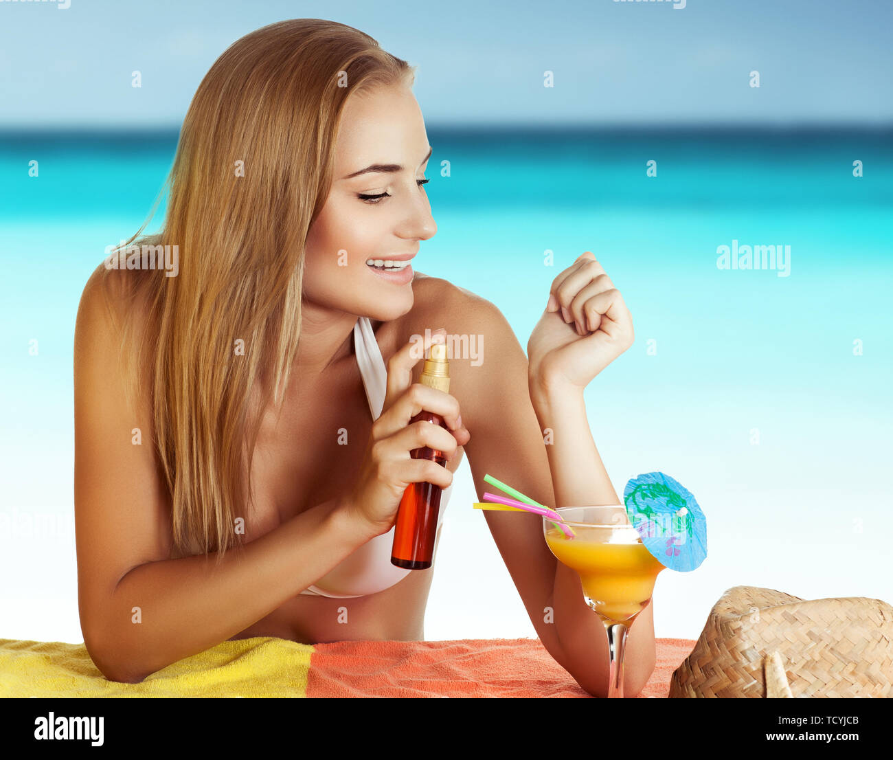 Portrait d'une jolie femme heureuse sur la plage, l'application de l'huile  de bronzage, soins du corps et de la peau, en appréciant les vacances d'été  Photo Stock - Alamy