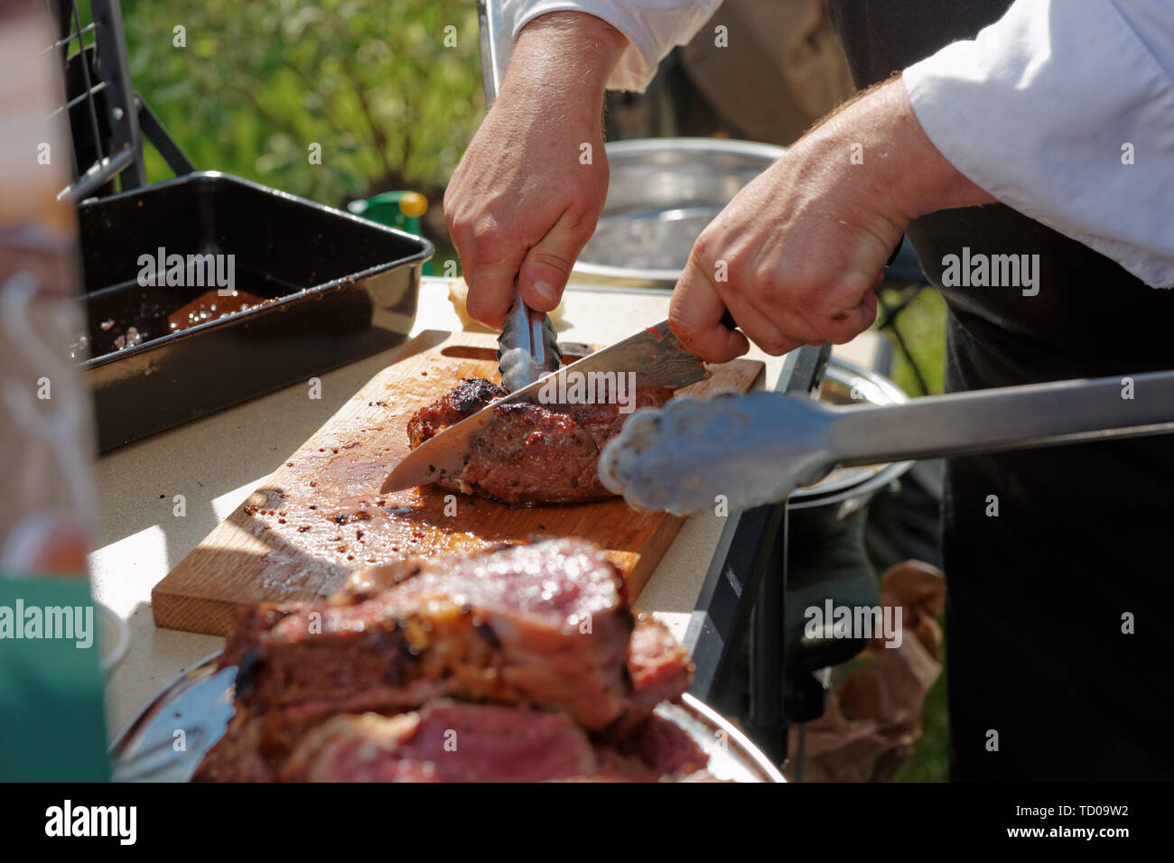 Chef, c'est couper la viande à la cuisine extérieure Banque D'Images