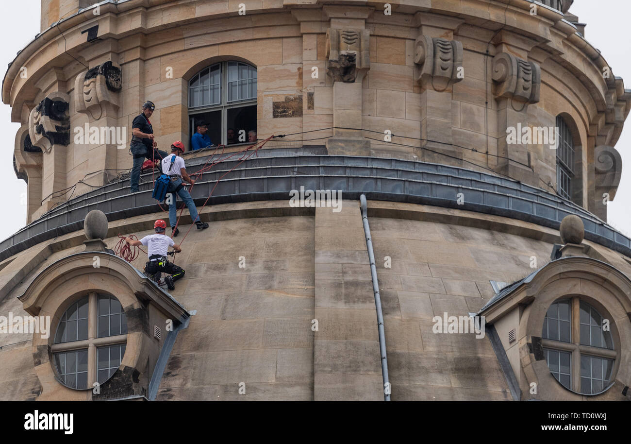 Dresde, Allemagne. 11 Juin, 2019. Les travailleurs en hauteur monter sur la coupole de la Frauenkirche à renouveler pour la soirée des feux l'allumage du dôme de pierre. Travaux d'entretien et de remplacement doit être effectuée sur un total de 40 appareils sur la lanterne, l'arbre du petit dome bâtiments et l'arrière de la tourelle d'escalier. Le travail est nécessaire parce que la lumière de l'éclairage précédent ne reflète plus suffisamment de l'obscurcissement de la pierre. Crédit : Robert Michael/dpa-Zentralbild/dpa/Alamy Live News Banque D'Images