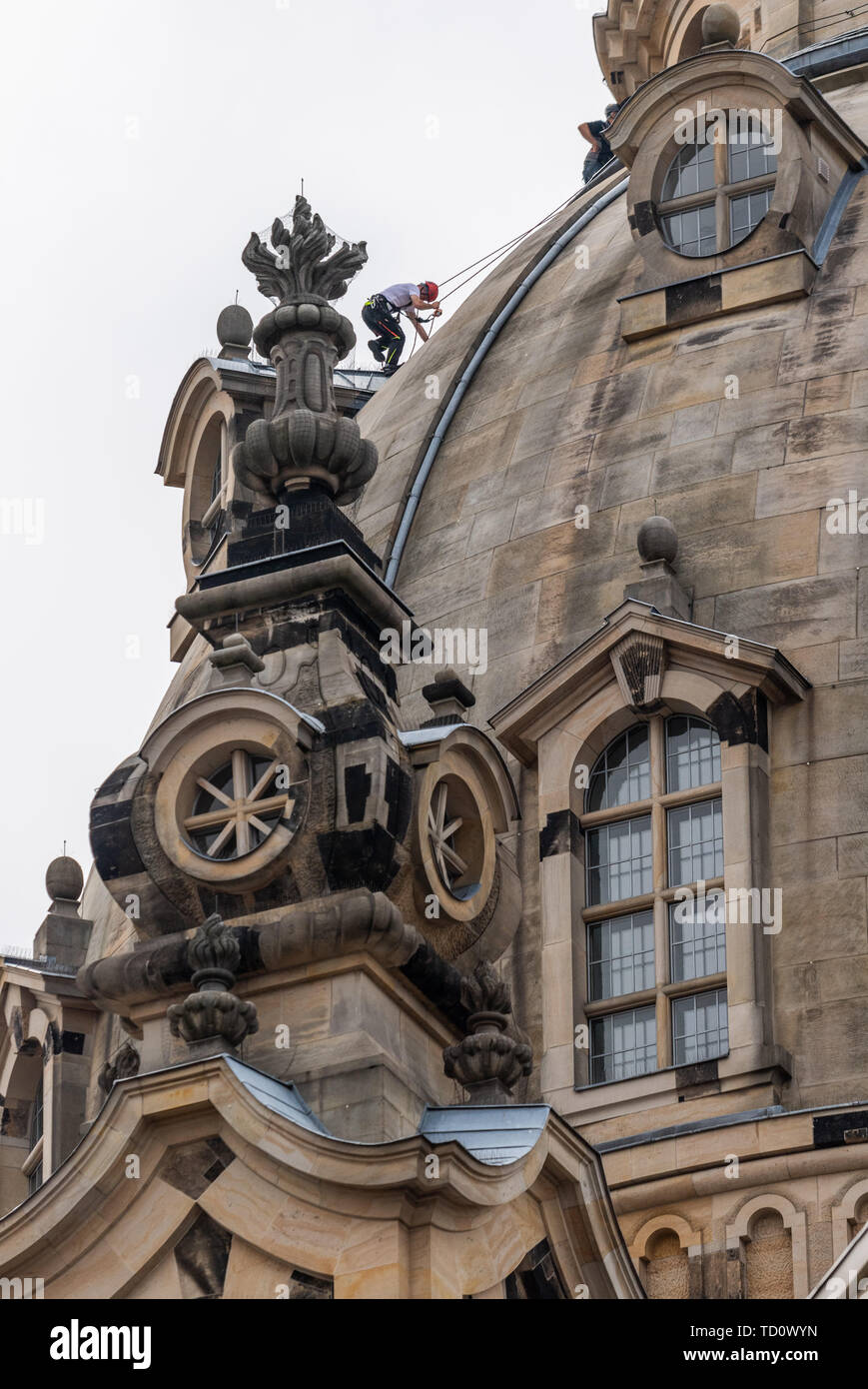 Dresde, Allemagne. 11 Juin, 2019. Un technicien accès sur corde grimpe sur la coupole de la Frauenkirche à renouveler pour la soirée des feux l'allumage du dôme de pierre. Travaux d'entretien et de remplacement doit être effectuée sur un total de 40 appareils sur la lanterne, l'arbre du petit dome bâtiments et l'arrière de la tourelle d'escalier. Le travail est nécessaire parce que la lumière de l'éclairage précédent ne reflète plus suffisamment de l'obscurcissement de la pierre. Crédit : Robert Michael/dpa-Zentralbild/dpa/Alamy Live News Banque D'Images