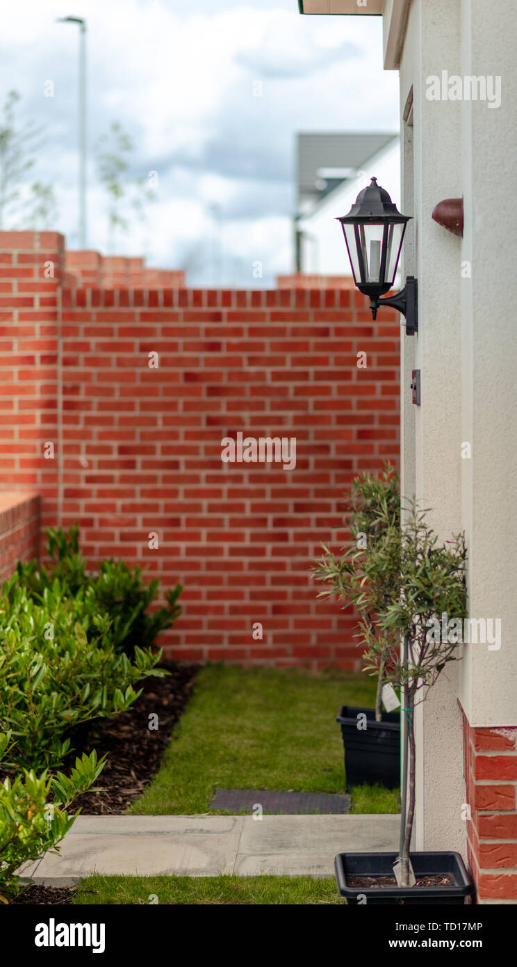 Jardin à l'avant d'une classe moyenne typique de la maison avec un jardin, plantes, mur de briques et de lumière de sécurité - prises à l'été 2019 Banque D'Images