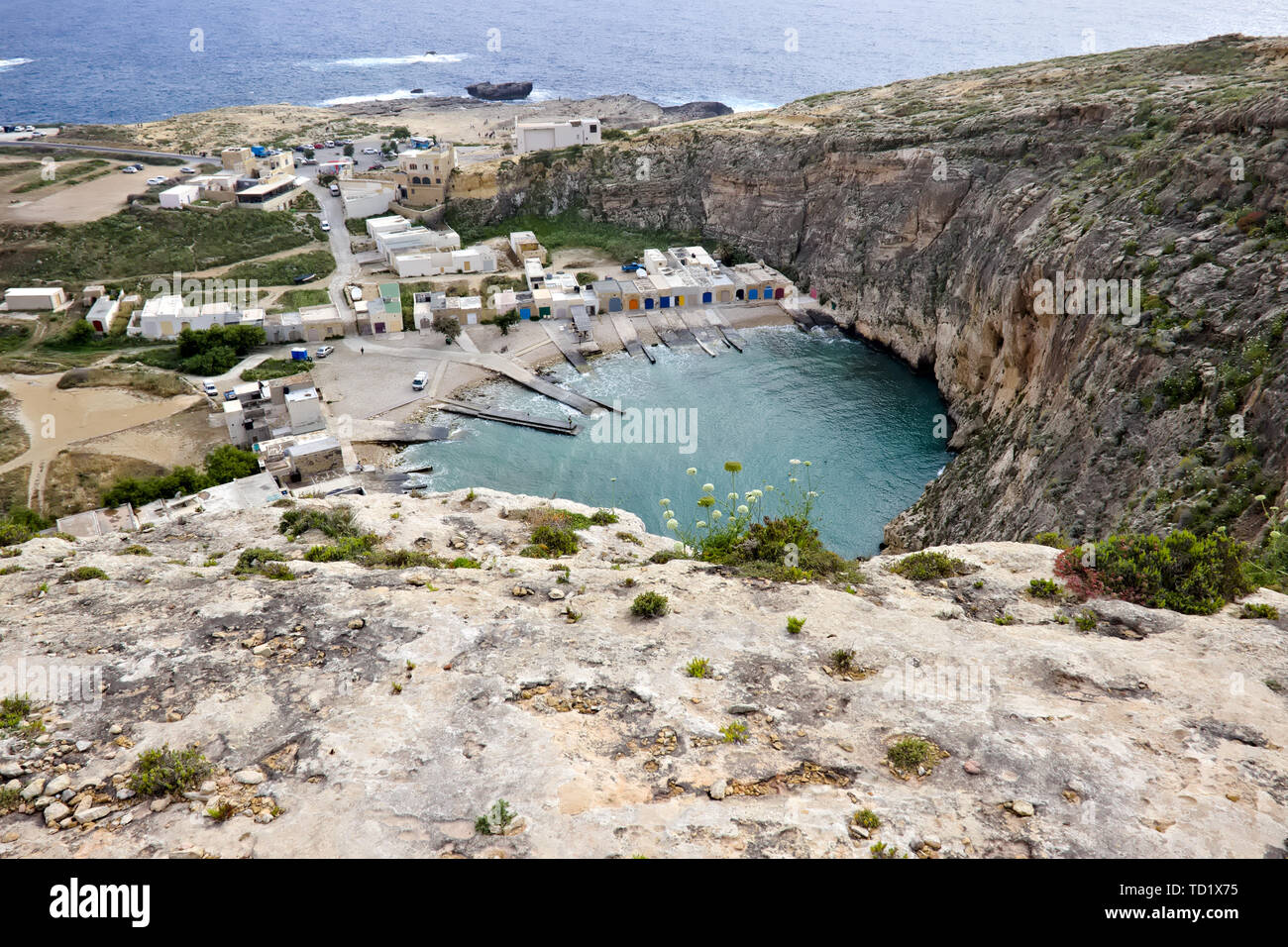 Spot de plongée (mer intérieure) avec peu de maisons et de l'océan bleu en arrière-plan vu du dessus à Gozo, Malte. Banque D'Images
