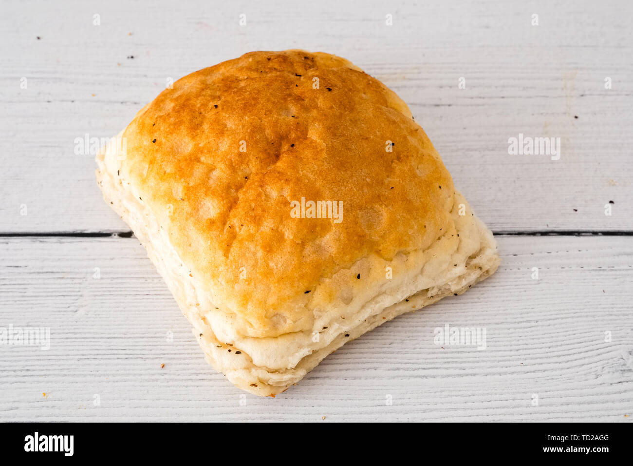 Pain croustillant de rouler sur une planche en bois et prêt à manger tout droit sorti de l'ovan. Une bonne image pour un boulanger ou similaire. Banque D'Images