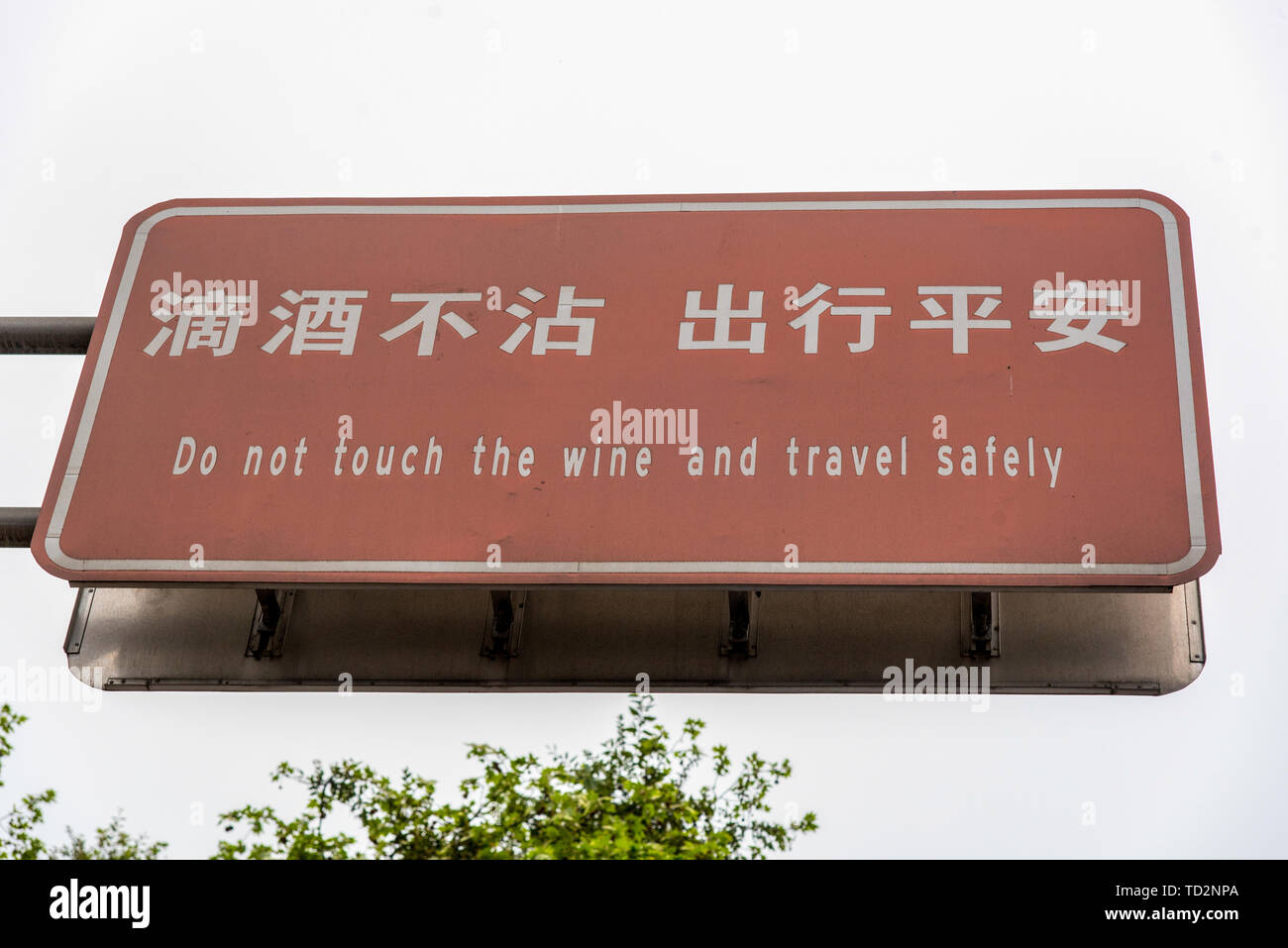 Ne touchez pas le vin et voyager en toute sécurité un signe en chinois et anglais photographié dans la ville de Dujiangyan, province du Sichuan, Chine Banque D'Images