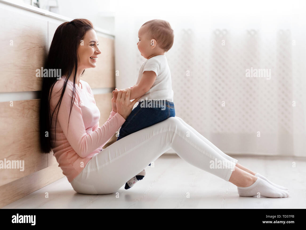 Belle mère jouer avec bébé adorable dans la cuisine Banque D'Images