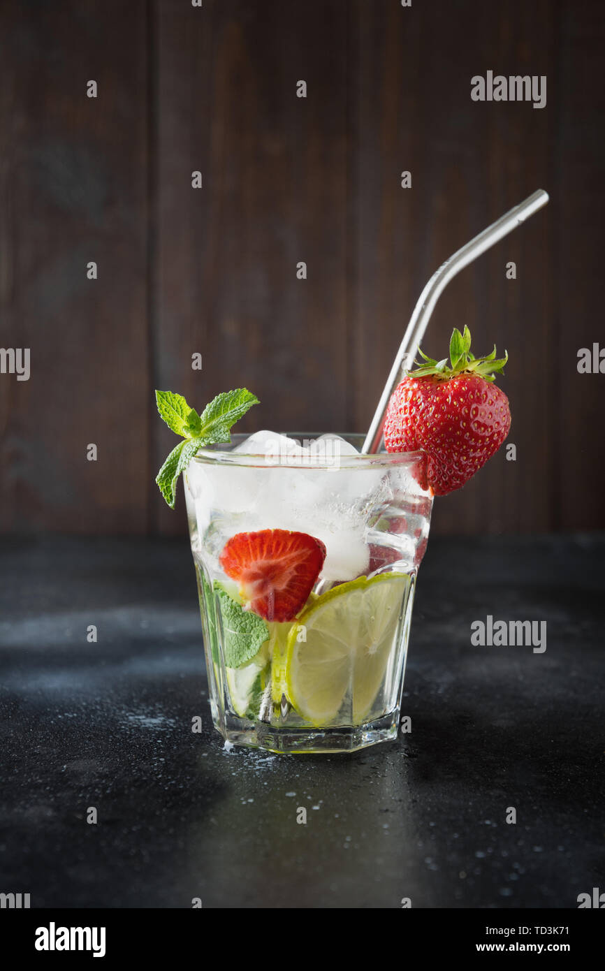 La désintoxication limonade ou mojito avec lime, citron, fraise au verre. Boisson saine d'été. Banque D'Images